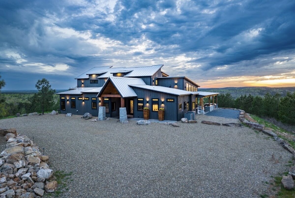 Restoration Point — a charcoal modern cabin on a hilltop under a dramatic cloudy sky