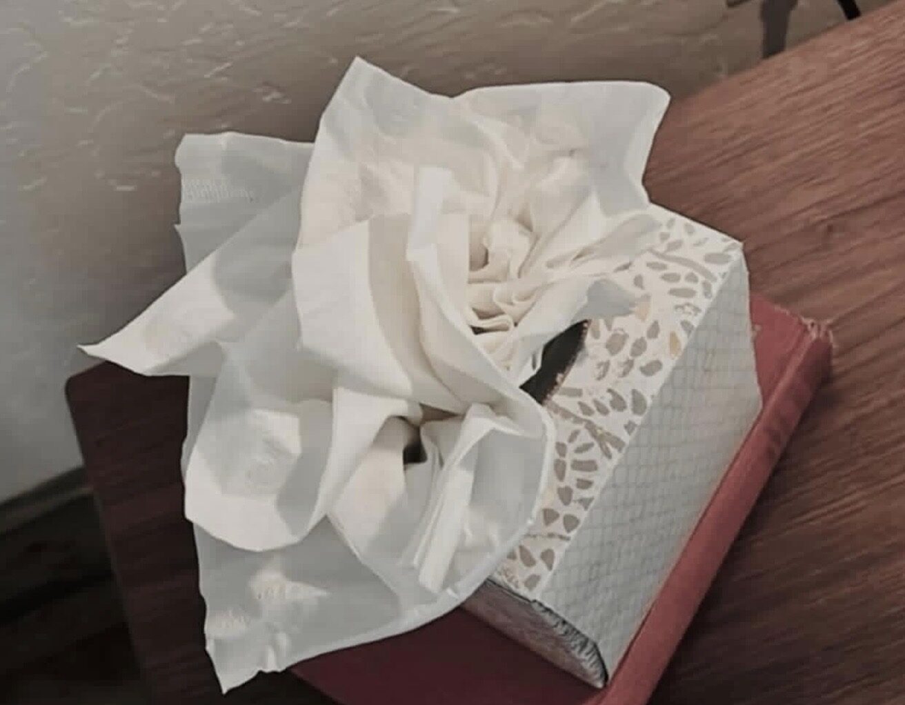 The first tissue in the box folded into the shape of a rose