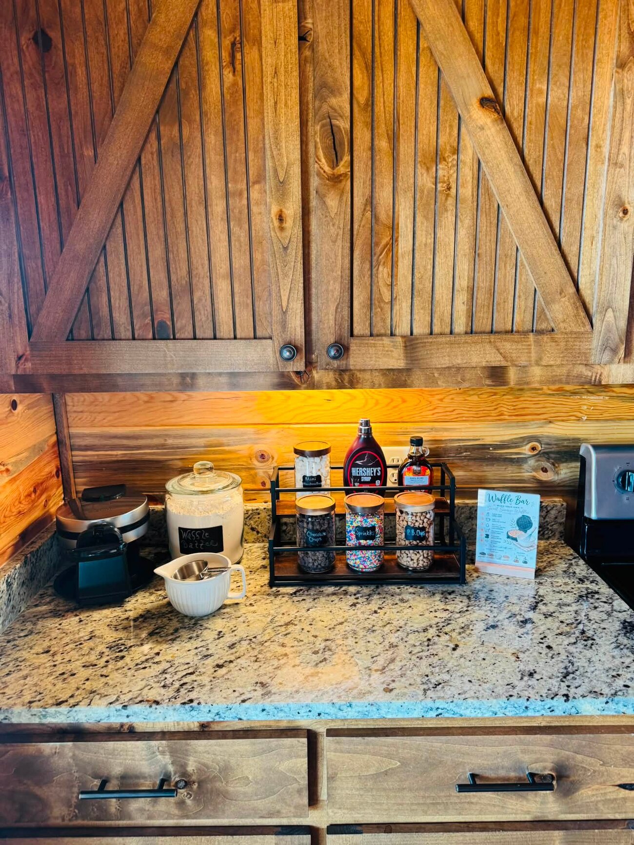 Waffle-bar corner with barn-door cabinets, granite counter, topping caddy and Waffle Bar sign